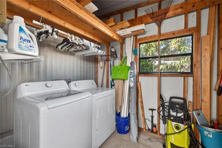 Laundry area with concrete flooring and washing machine and clothes dryer
