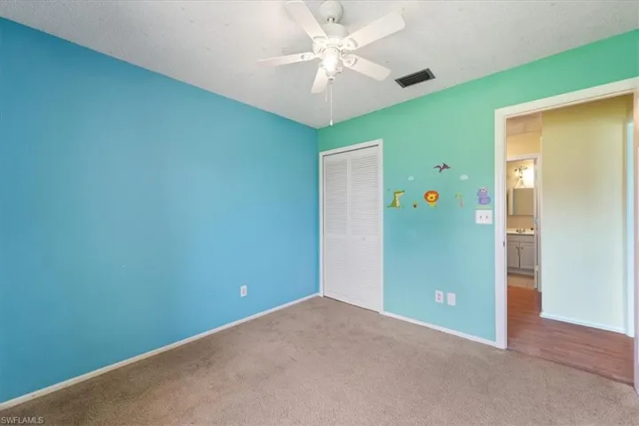 Unfurnished bedroom featuring carpet, a closet, a ceiling fan, and a textured ceiling