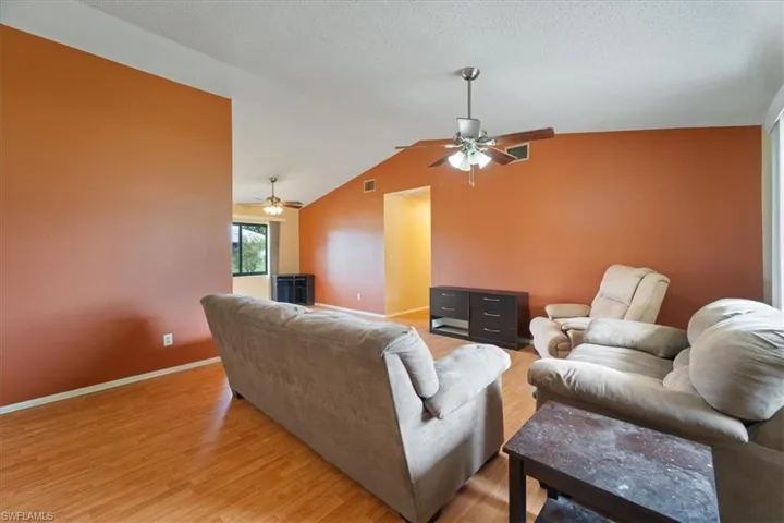 Living room featuring lofted ceiling and light wood finished floors