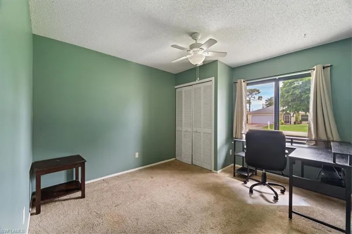 Office area with carpet floors, a textured ceiling, and ceiling fan