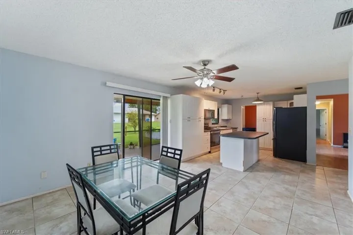 Dining area with a textured ceiling, light tile patterned floors, and a ceiling fan