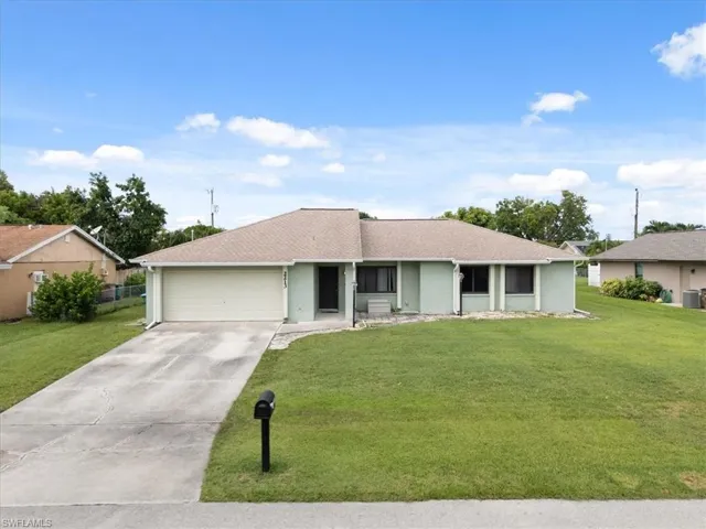 Ranch-style house with a front lawn, driveway, an attached garage, stucco siding, and roof with shingles