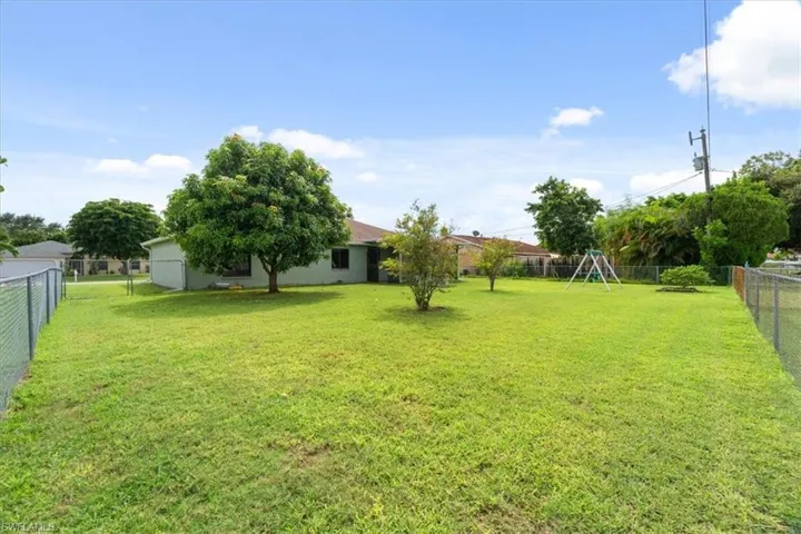 Fenced backyard featuring a playground