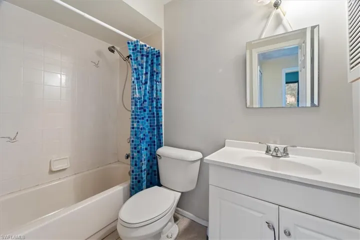 Bathroom featuring shower / bathtub combination with curtain and vanity