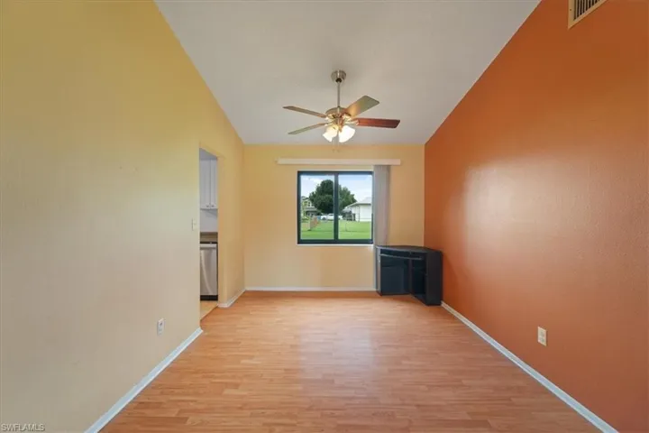 Unfurnished living room with light wood-style flooring, ceiling fan, and lofted ceiling