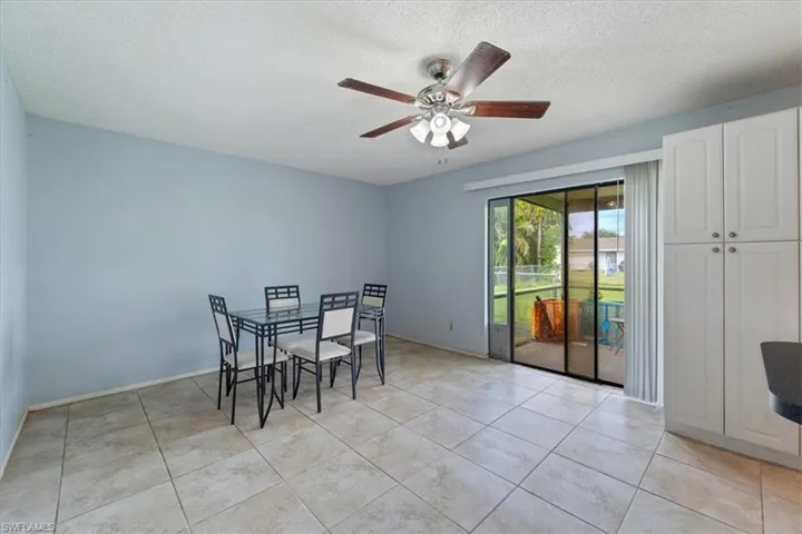 Dining area featuring a textured ceiling, light tile patterned floors, and ceiling fan