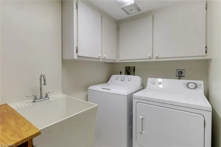 Washroom with washer and dryer, cabinet space, and a sink