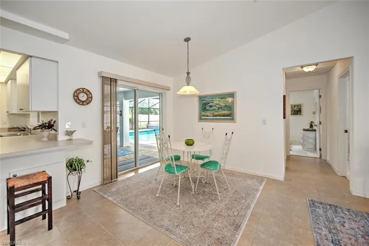 Tiled dining area with vaulted ceiling and sink