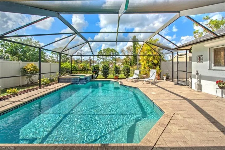 View of swimming pool with an in ground hot tub, a lanai, and a patio area
