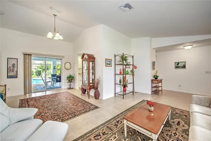 Tiled living room with vaulted ceiling and a chandelier