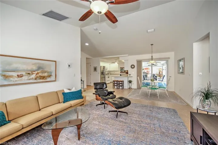 Tiled living room featuring lofted ceiling and ceiling fan