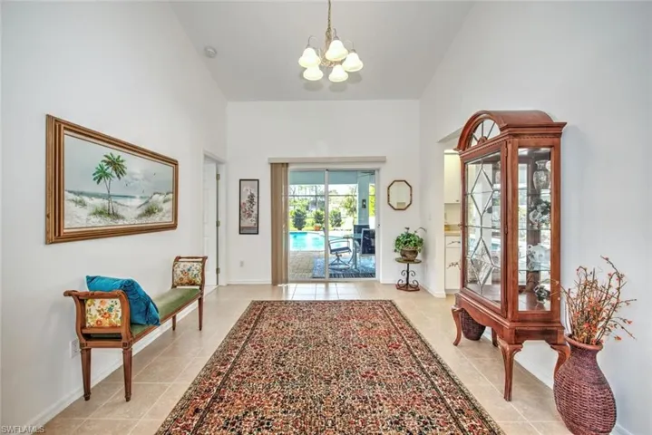 Tiled foyer entrance with an inviting chandelier and high vaulted ceiling
