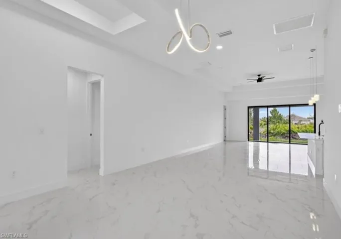 Spare room featuring a chandelier, light marble finish flooring, recessed lighting, and a ceiling fan