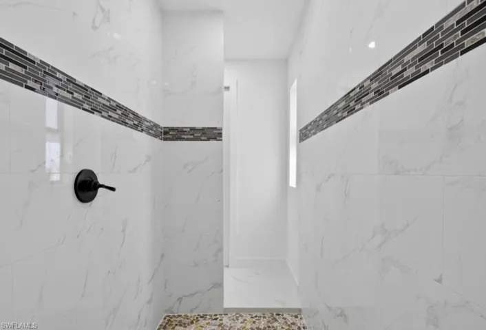 Full bathroom with a marble finish shower