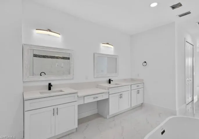 Full bathroom featuring light marble finish flooring, recessed lighting, double vanity, a freestanding bath, and a marble finish shower