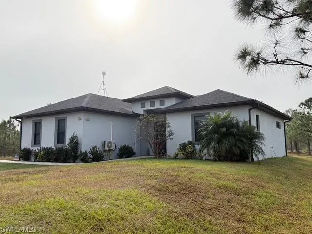 View of side of property with a yard and stucco siding