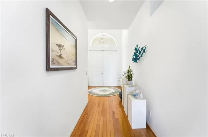 Corridor featuring hardwood / wood-style floors and suspended lighting