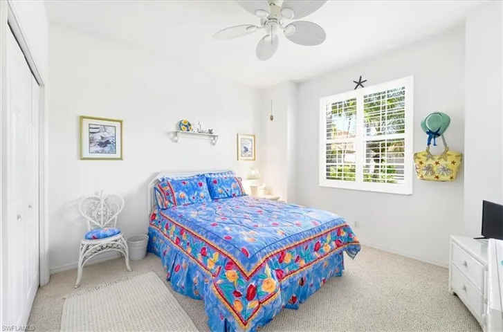 Bedroom with ceiling fan, carpet, and a closet