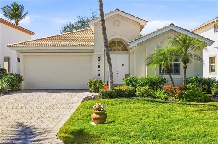 Mediterranean / spanish house with an attached garage, decorative driveway, and stucco siding