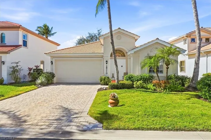 Mediterranean / spanish-style home with a garage, decorative driveway, stucco siding, a front lawn, and a tiled roof