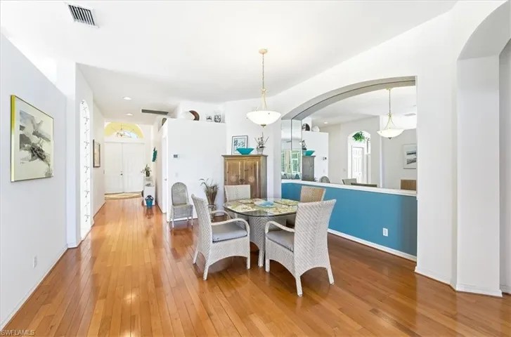 Dining room with hardwood / wood-style floors and arched walkways