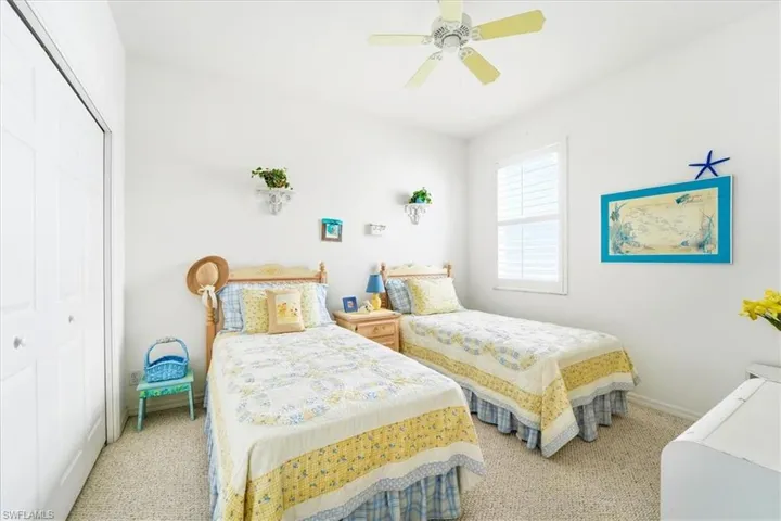 Carpeted bedroom featuring a closet and a ceiling fan