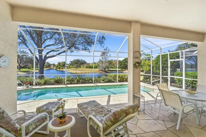 Swimming pool with a sunroom, a patio, a lanai, and a water view
