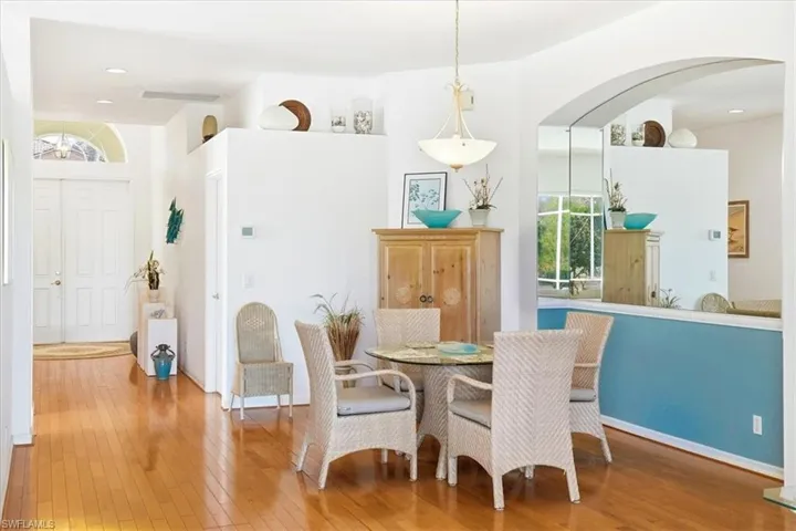 Dining area featuring arched walkways, recessed lighting, and hardwood / wood-style floors