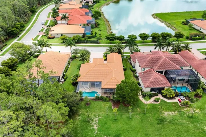 Aerial view of residential area featuring a pool area and a large body of water