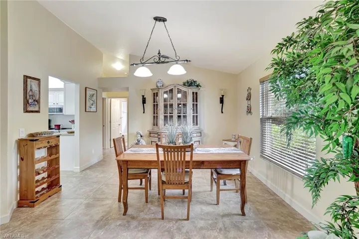 Dining space featuring vaulted ceiling and baseboards