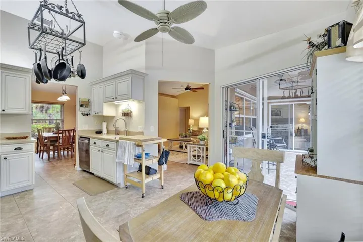 Dining room featuring a ceiling fan, a towering ceiling, and a chandelier