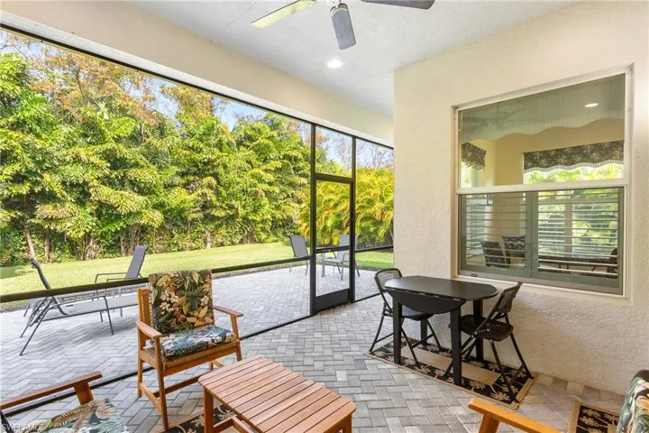 Sunroom featuring a textured wall, brick flooring, and view of scattered trees