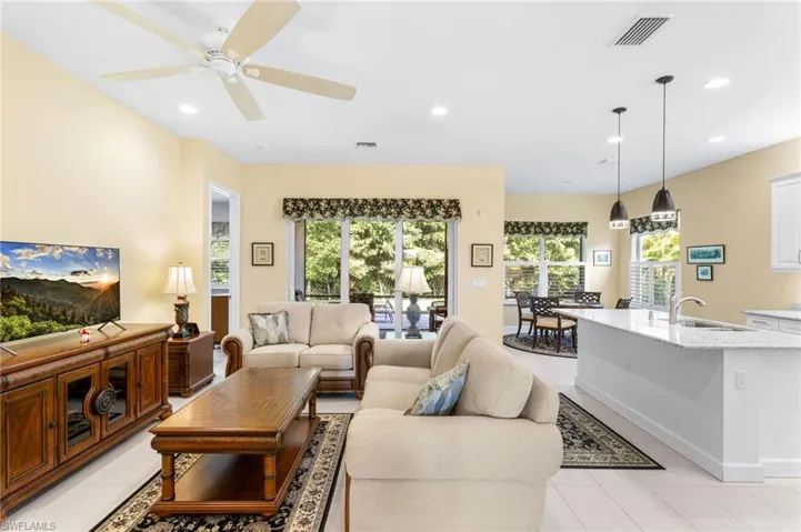 Living area featuring healthy amount of natural light, recessed lighting, light tile patterned floors, and a ceiling fan