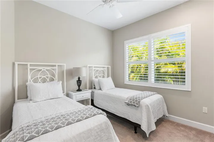 Carpeted bedroom featuring baseboards and a ceiling fan