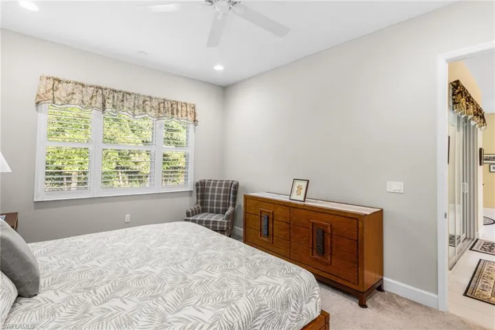 Bedroom with light colored carpet, ceiling fan, and recessed lighting