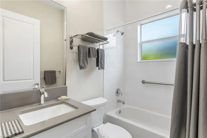 Full bath featuring shower / bath combination with curtain and vanity