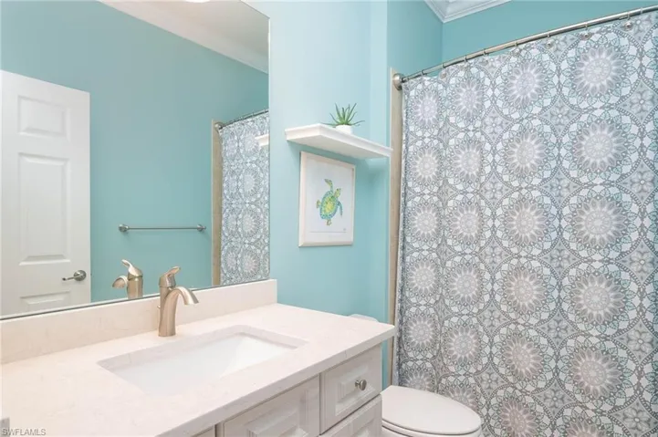 Bathroom featuring vanity, toilet, and crown molding