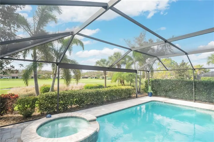 View of swimming pool enclosure and an in ground hot tub