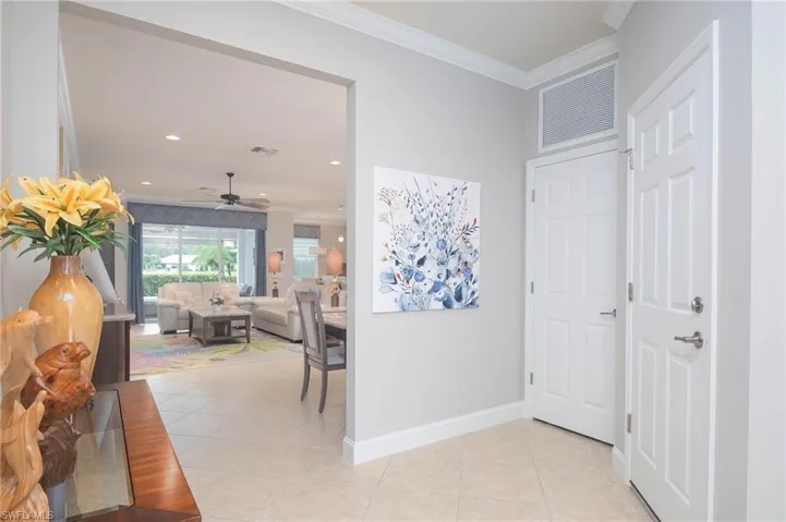 Entry featuring light tile floors and ornamental molding