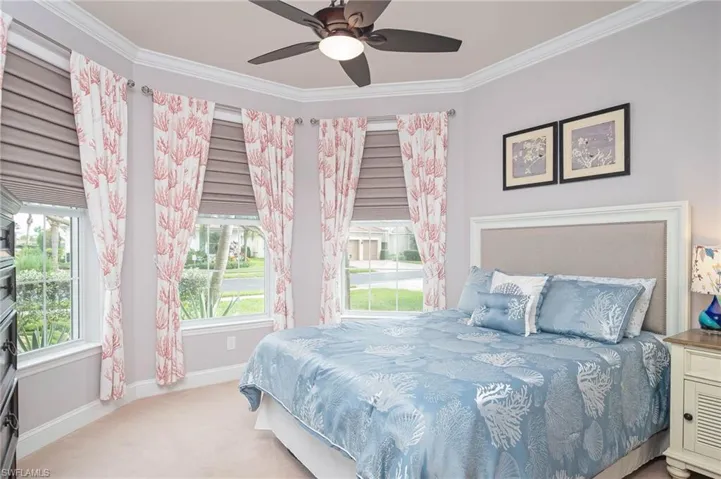 Bedroom with multiple windows, ceiling fan, crown molding, and light colored carpet