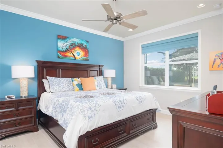 Bedroom with ceiling fan, ornamental molding, and light hardwood / wood-style flooring