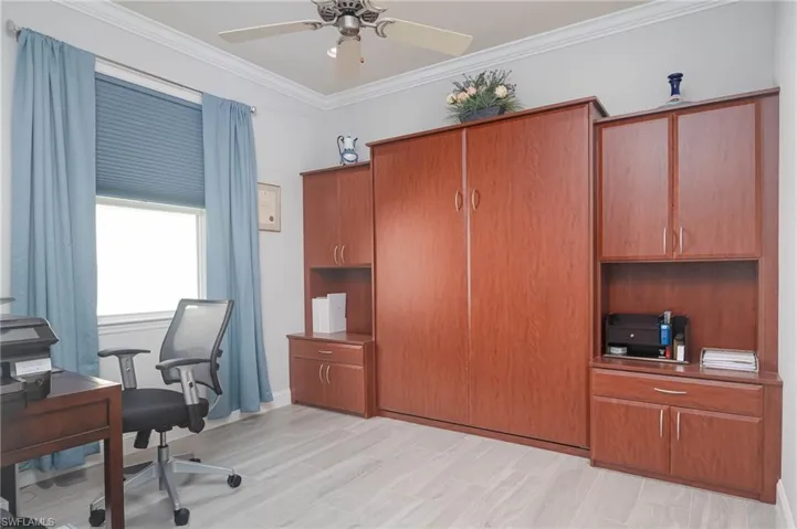 Office space featuring ceiling fan, ornamental molding, and light hardwood / wood-style flooring