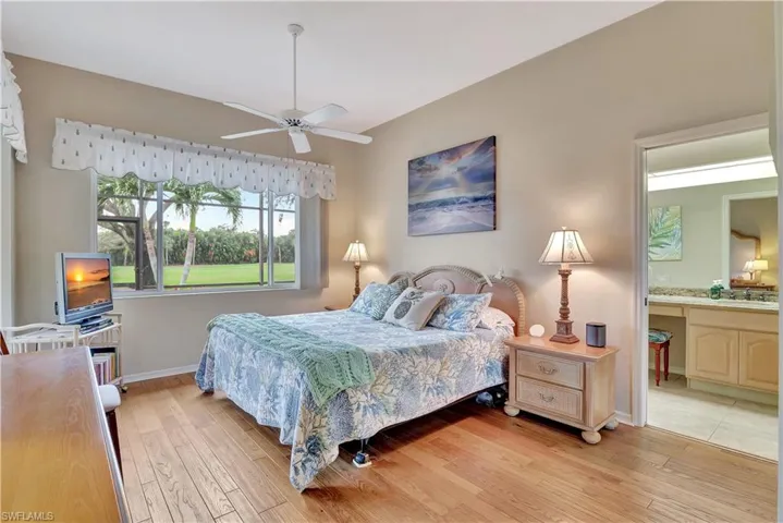 Bedroom with ceiling fan, connected bathroom, and hardwood / wood-style flooring