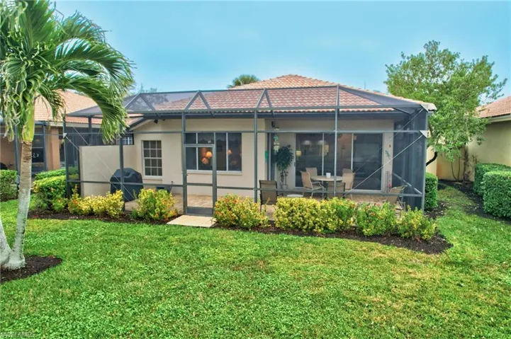 Rear view of property with a patio area, a lanai, and a yard