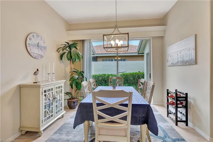 Dining area with light tile patterned floors and an inviting chandelier