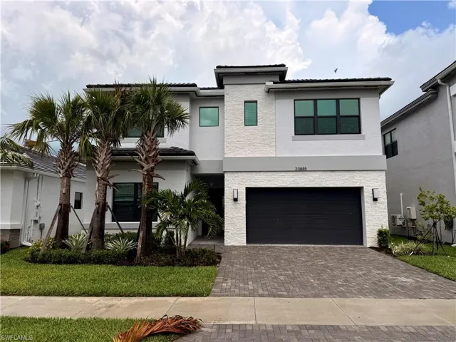 Modern two-story residence with a dark-tiled roof and white textured exterior