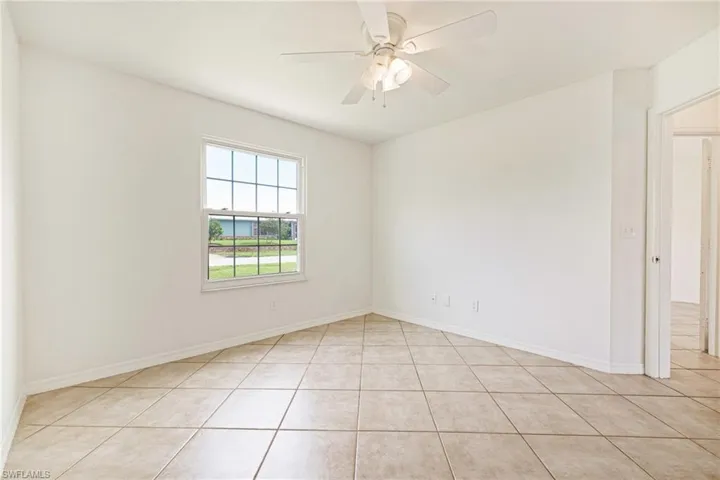 Unfurnished room featuring light tile patterned floors and a ceiling fan