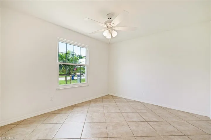 Unfurnished room featuring light tile patterned floors and a ceiling fan