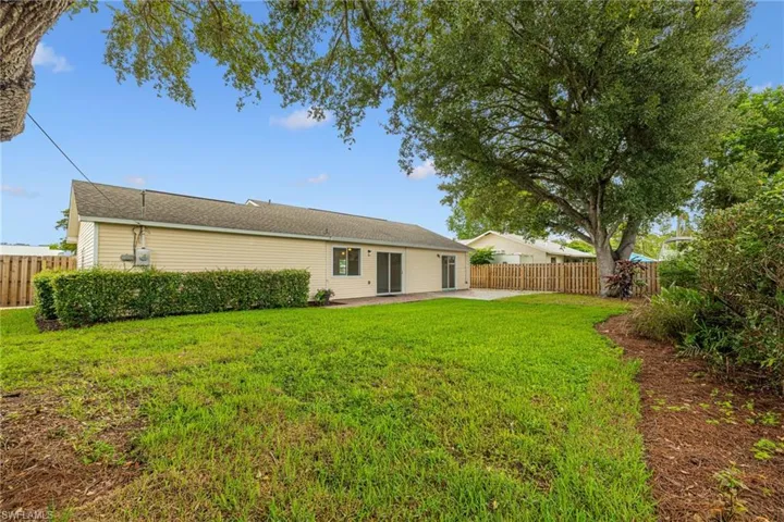 Rear view of house featuring a patio area and a fenced backyard