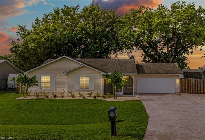 Single story home with concrete driveway and an attached garage
